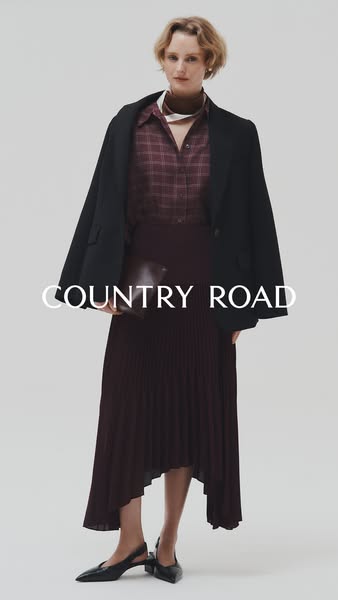 This ad showcases a woman wearing Country Road clothing, including a black blazer, a maroon plaid blouse, a maroon pleat