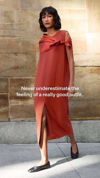 This image ad showcases a woman modeling a rust colored dress with an interesting shoulder detail. The ad emphasizes the