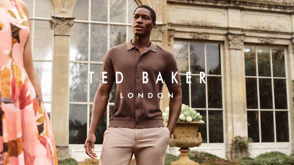 An image promoting Ted Baker London. A man wearing Ted Baker apparel poses in front of a stately building.
