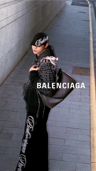 This ad features a person wearing Balenciaga apparel and carrying a Balenciaga handbag. The ad showcases the brand's