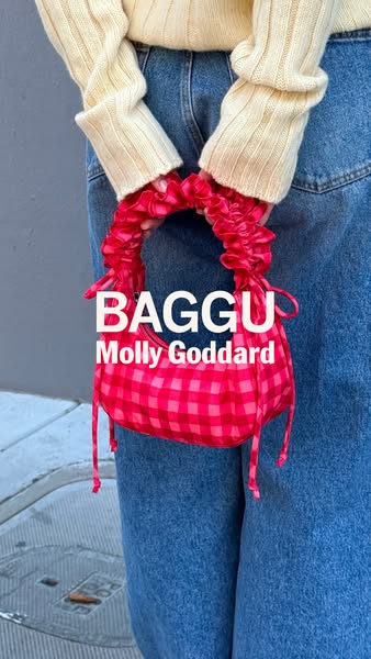This ad showcases a pink gingham BAGGU purse in collaboration with Molly Goddard. The purse is held by a person wearing 