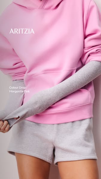 This Aritzia ad showcases a cozy pink hoodie and grey sweatshorts set, emphasizing the comfort and style of the brand