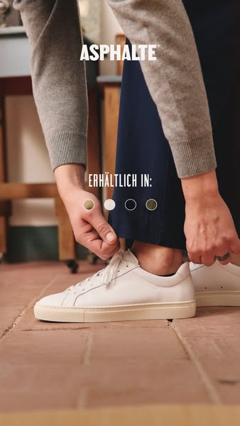 This ad features a close up shot of a person tying the laces of a pair of white Asphalté sneakers.