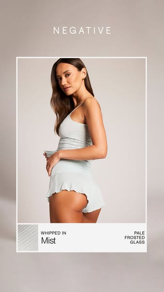 This ad features a woman modeling Negative brand loungewear, specifically a camisole and shorts set in the color "M