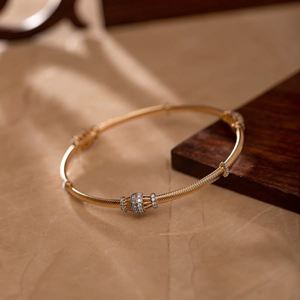 This ad showcases a gold bracelet with diamond accents. The image is a close-up shot of the bracelet on a neutral surfac