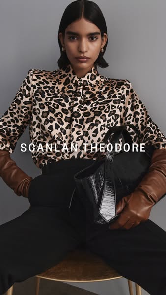 This ad features a model seated on a chair, wearing a printed shirt with black pants and brown leather gloves, and carry