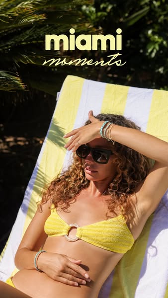 An image ad promoting bracelets. The ad shows a woman lying on a yellow and white striped towel. She is wearing a yellow