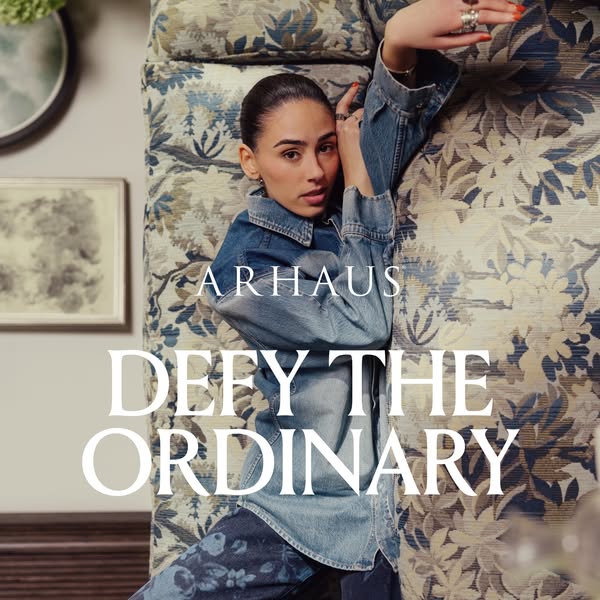 This image ad for Arhaus features a model lounging on a floral patterned sofa, with a call to defy the ordinary.