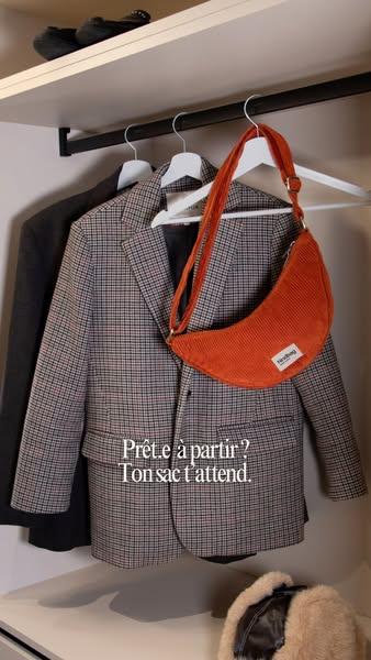 The ad showcases a burnt orange purse hanging on a hanger next to suit jackets with text that reads "Prête.e à part