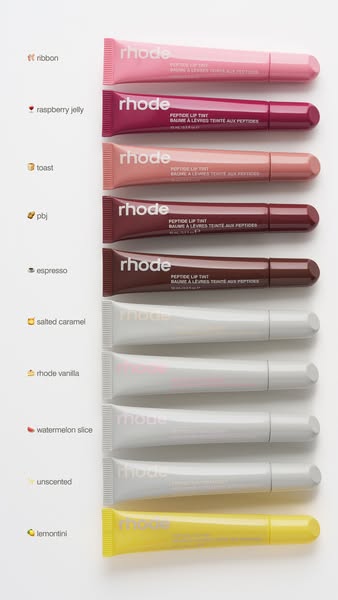This ad features a flatlay of Rhode Peptide Lip Tints in various shades, each labeled with a corresponding emoji and fla