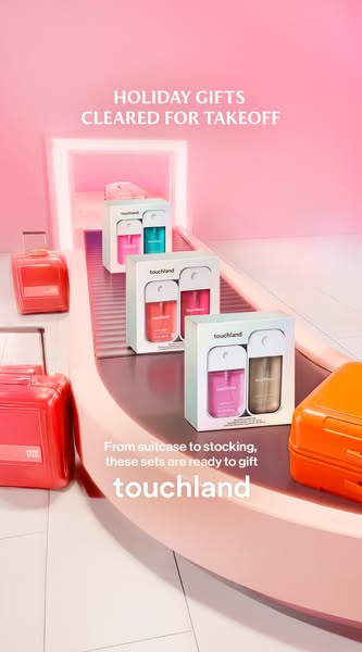 This ad showcases Touchland hand sanitizer sets as holiday gifts, using a conveyor belt and suitcase props to create a p