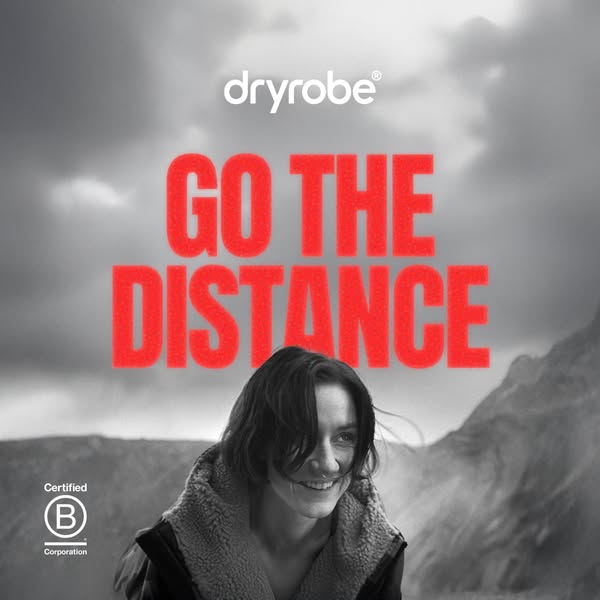 This image ad for Dryrobe features a woman smiling in front of a mountain range. The ad's headline encourages viewer