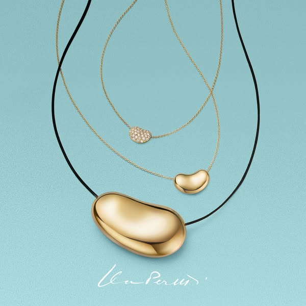 An ad showcasing the Elsa Peretti bean pendant necklaces in different sizes and materials.