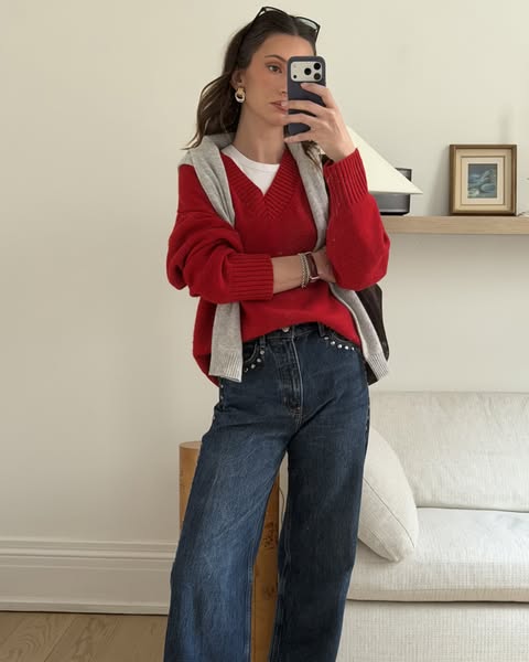 This ad features a woman showcasing a casual outfit consisting of jeans, a white t-shirt, a red sweater, and a gray swea