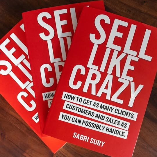 This ad features three copies of the book "Sell Like Crazy" by Sabri Suby. The ad highlights the book's ti