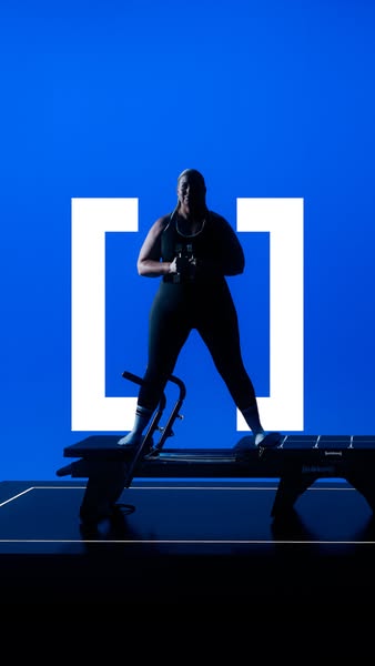 An image ad featuring a woman using a CLMBR machine with a simple blue background and a logo in the center.