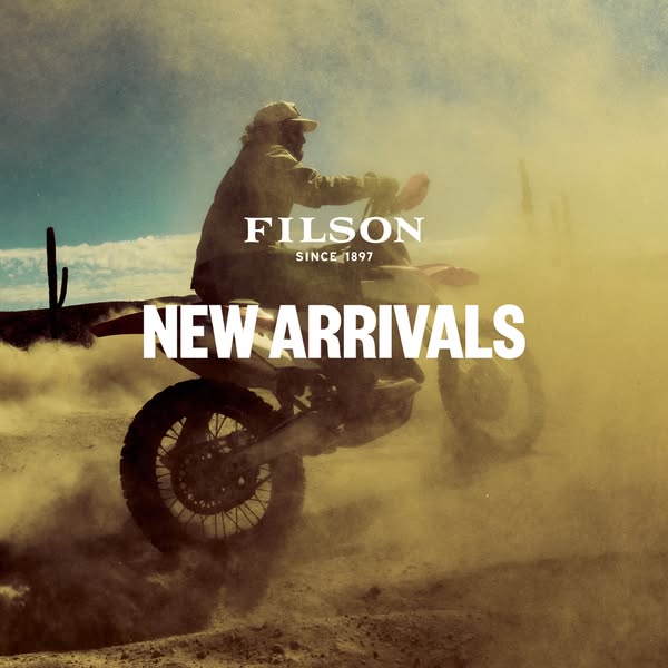 This ad features a person riding a motorcycle through a dusty desert landscape, promoting Filson's new arrivals. The