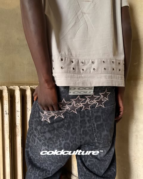 A close-up shot focusing on the back of a person wearing dark gray jeans with a leopard print, accentuated by a line of 