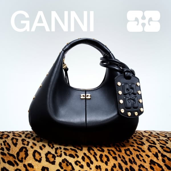 This image ad features a black leather Ganni purse with gold studs on a leopard print surface. The ad focuses on the pro