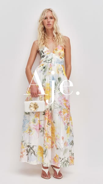 This ad showcases a woman wearing a floral dress and holding a white purse with a gold flower on it.