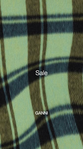 This ad for GANNI promotes a sale on the brand's items, displayed against a backdrop of plaid material.