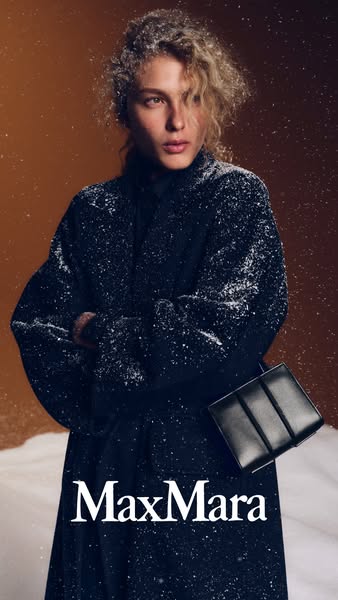 This ad showcases a woman in a wintery setting wearing a Max Mara coat and carrying a Max Mara handbag. The ad emphasize