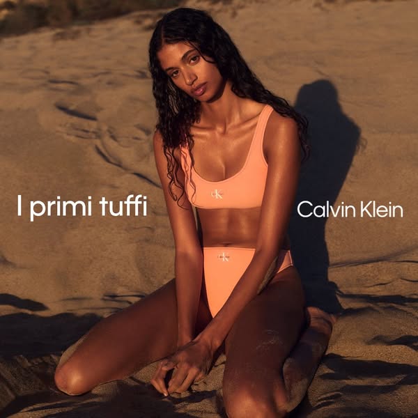 This ad is for Calvin Klein swimwear, featuring a woman in a coral bikini on a sandy beach. The ad is in Italian.