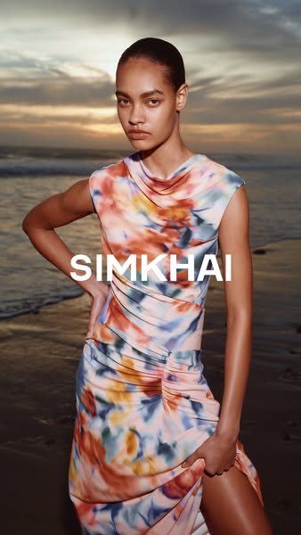 This ad features a woman modeling a SIMKHAI dress on a beach at sunset. The advertisement uses a photo as a canvas, disp