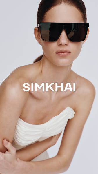 This ad showcases a woman in a dress and sunglasses, and features the brand name.
