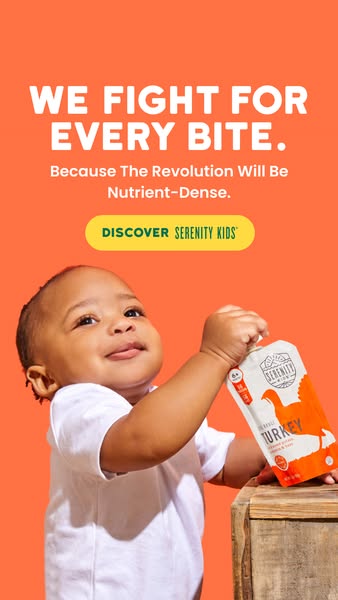 This image ad for Serenity Kids baby food uses a close-up shot of a baby holding a pouch of the brand's turkey puree