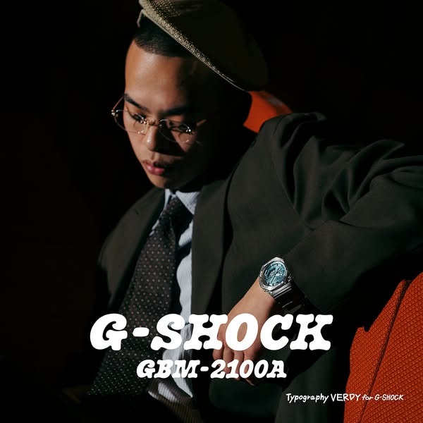 This ad shows a fashionable man wearing a suit and hat to display the G-SHOCK GBM-2100A watch on his wrist.