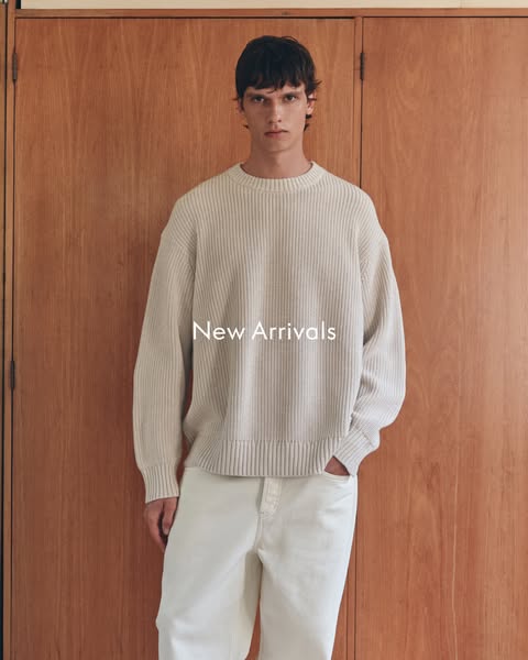 The ad features a person modeling a light beige knit sweater and matching cream pants in front of a wood paneled wall. T