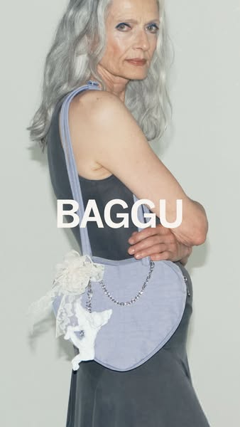 This ad features an older female model carrying a Baggu purse. The shot is editorial in style, with a fashion-forward fe