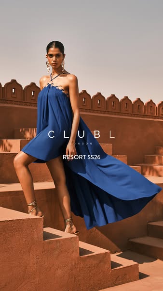 This ad features a model walking on stairs wearing a long blue dress.