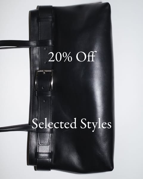 This ad features a black leather tote bag against a white background. Text layered on the image advertises a 20% off sal