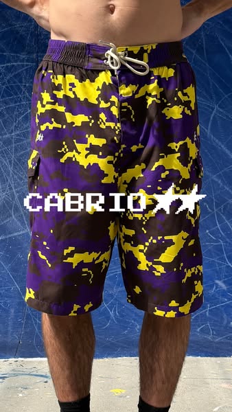 The ad showcases Cabrio brand shorts in a pixelated camouflage pattern. The image focuses on the unique design and aims 