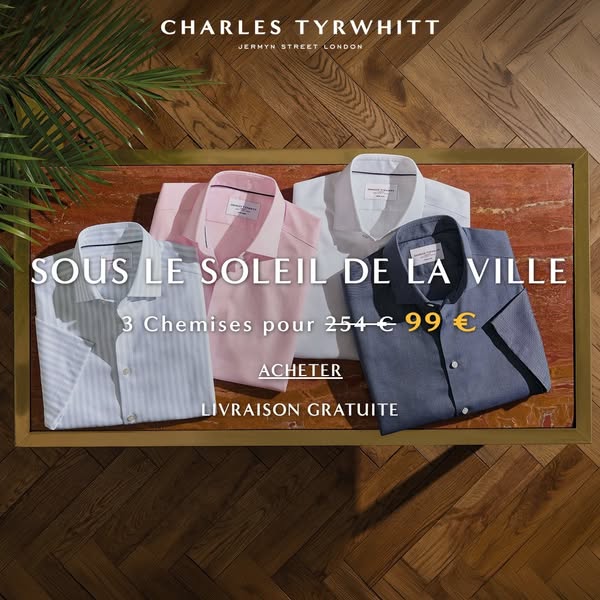 This ad showcases a flatlay shot of four Charles Tyrwhitt shirts in different colors, neatly folded on a wooden table. T