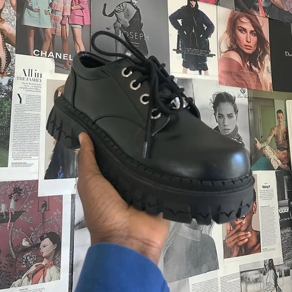 This ad showcases a chunky black platform shoe being held by a hand, presented against a background collage of magazine
