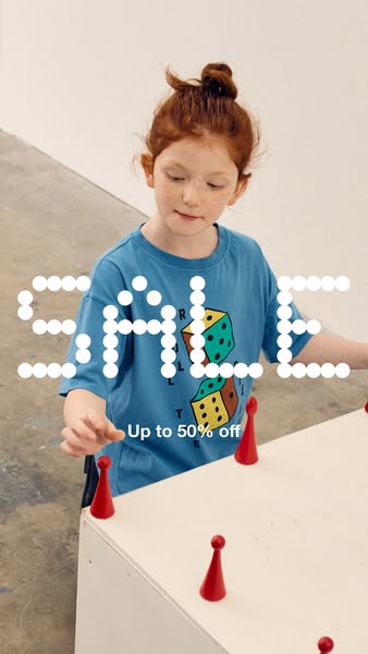 This ad features a young girl playing with red game pieces on a white table. The ad promotes a sale of up to 50% off.