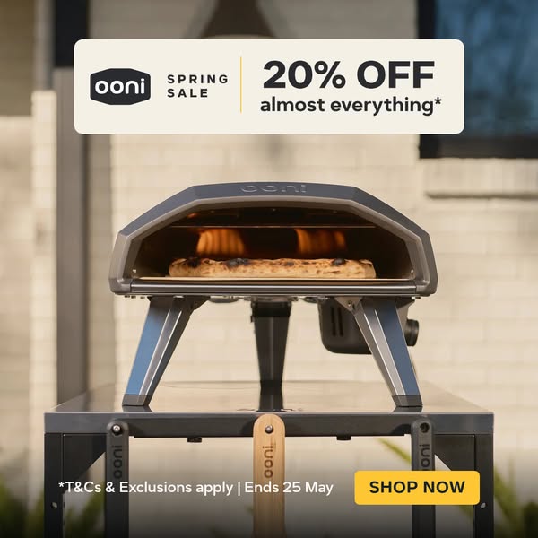 An image ad showcasing an Ooni pizza oven on a metal table outside a home. The ad promotes a Spring Sale offering 20% of