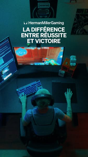 This image ad for Herman Miller Gaming features a gamer sitting at a desk with two monitors, a keyboard, and a mouse. Th