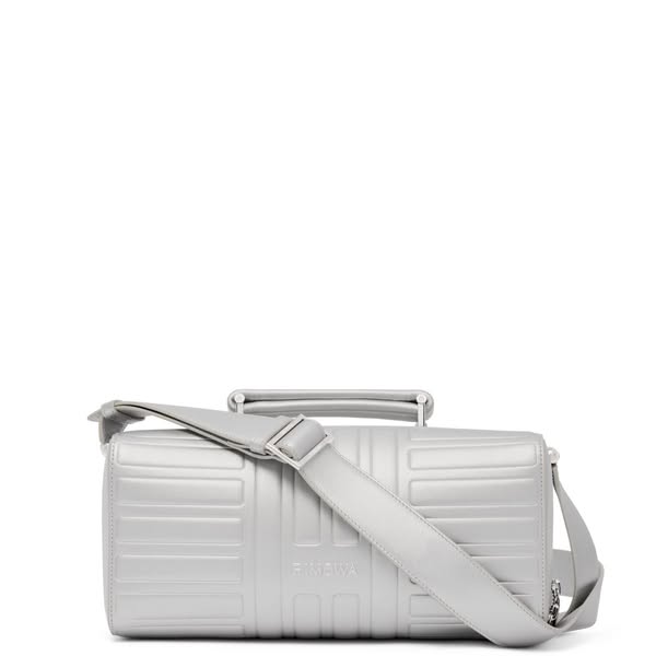 This ad features a single product shot of a RIMOWA bag. The bag is silver and has a rectangular shape with a handle on t