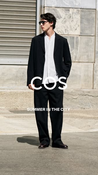 An image ad for COS features a model wearing apparel from their summer collection in an urban setting. The ad is simply 