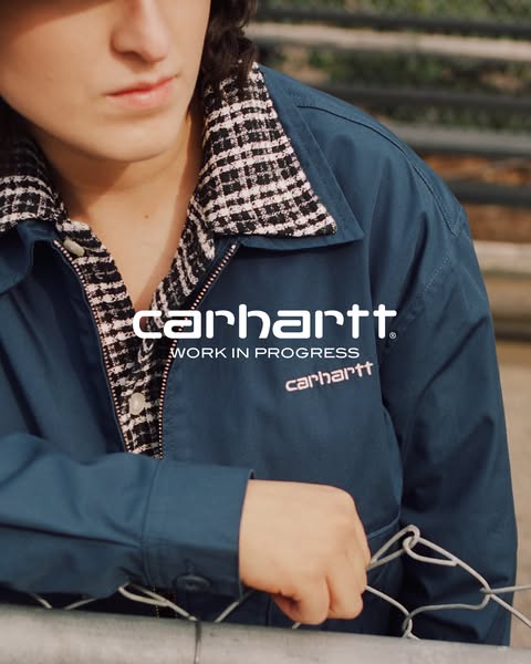 This ad features a close-up of a blue Carhartt jacket, highlighting the brand logo and workwear aesthetic. The focus is 