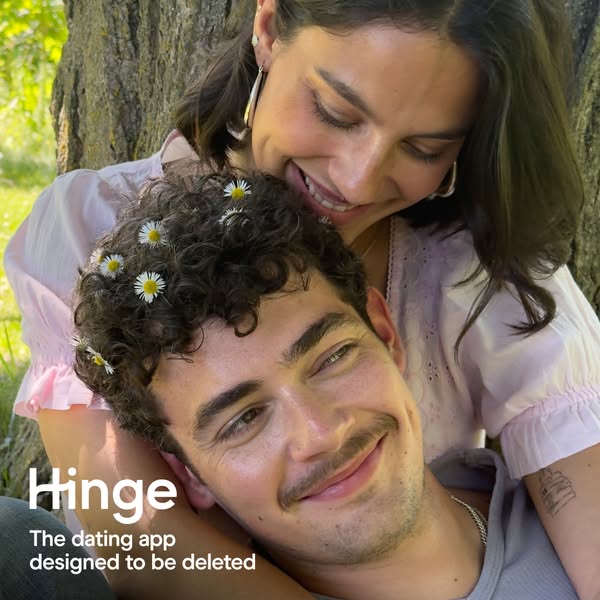 This image ad for Hinge features a young couple smiling at each other while sitting under a tree. The ad emphasizes the 