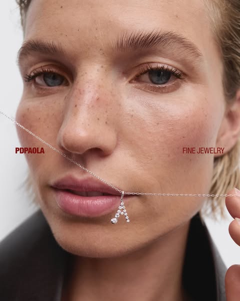 This ad features a close-up shot of a woman wearing a silver necklace with an 'A' pendant. The ad highlights the