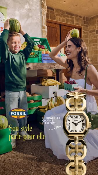 This Fossil ad features a woman and child at an outdoor fruit stand. The ad highlights the brand's watch and states 