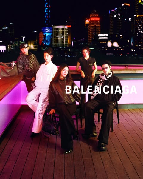 This ad features a group of models in an urban setting, showcasing Balenciaga products.