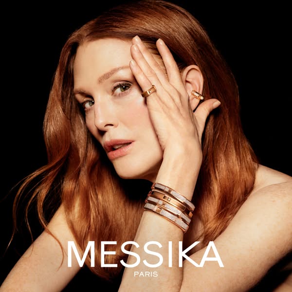 A luxury jewelry ad for Messika Paris featuring a female model wearing the brand's ring, ear cuff, and several brace