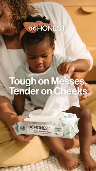This ad for Honest Company Clean Conscious Wipes features an African-American infant sitting on an adult's lap, inte